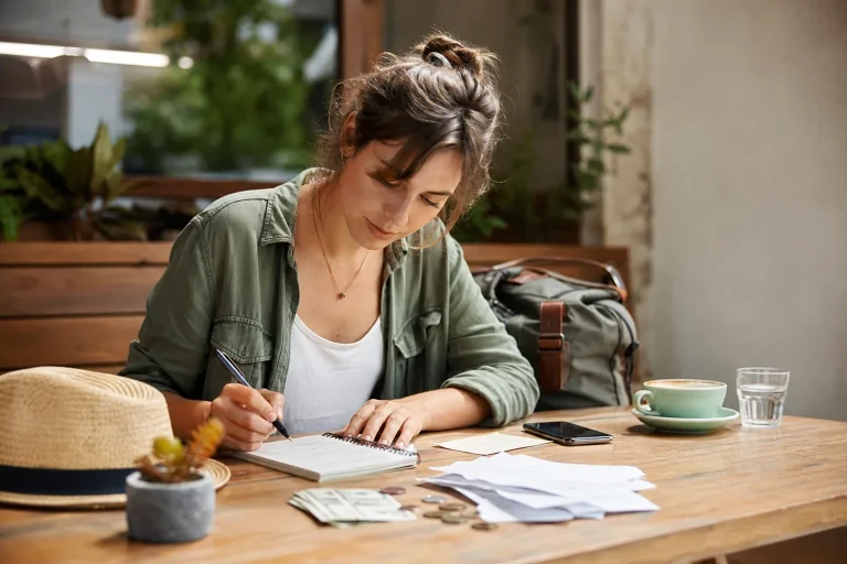 Traveller calculates the daily travel budget on a notebook