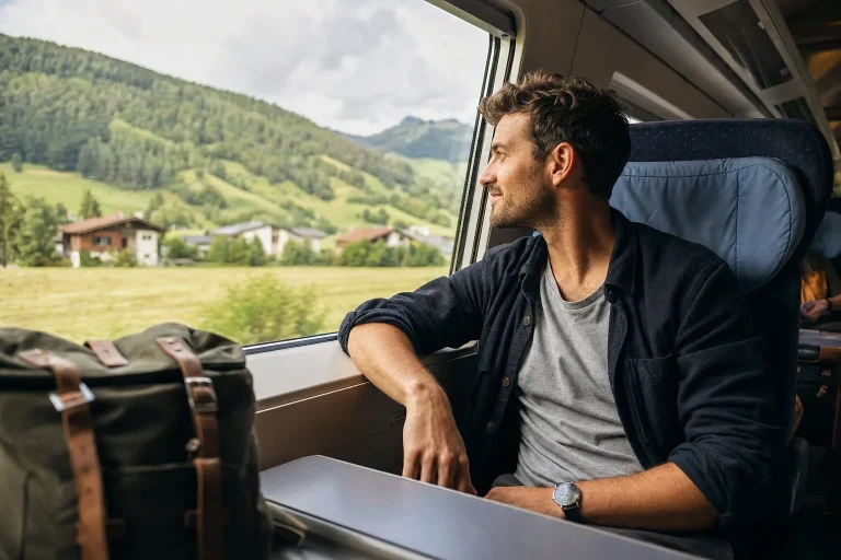 Traveller alone observes the landscape from a European train